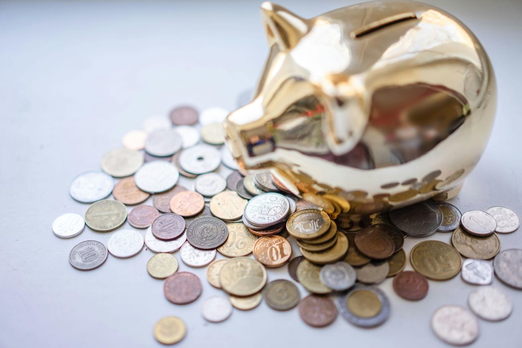Ein goldenes Sparschwein und viele Münzen