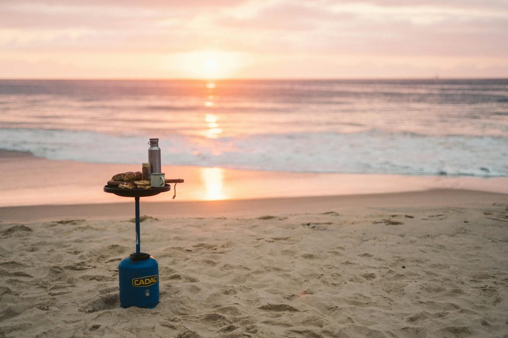 Ein Sonnenuntergang am Meer und eine Kochstelle vor dem Wasser