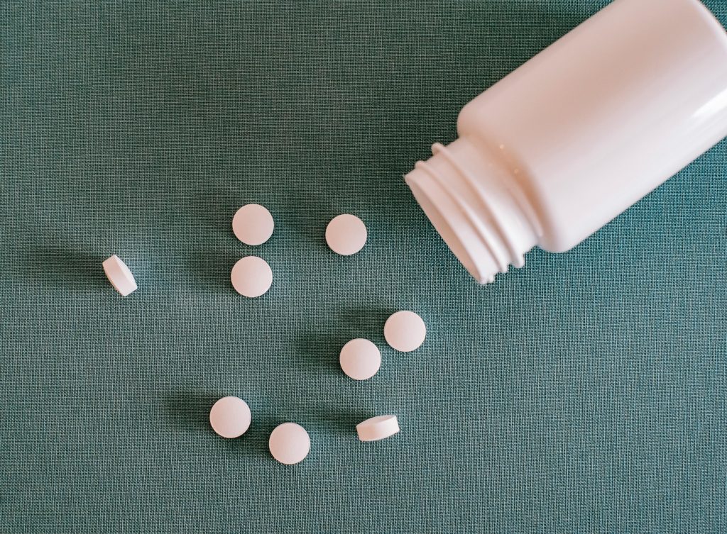 weiße Tabletten neben einer Dose
