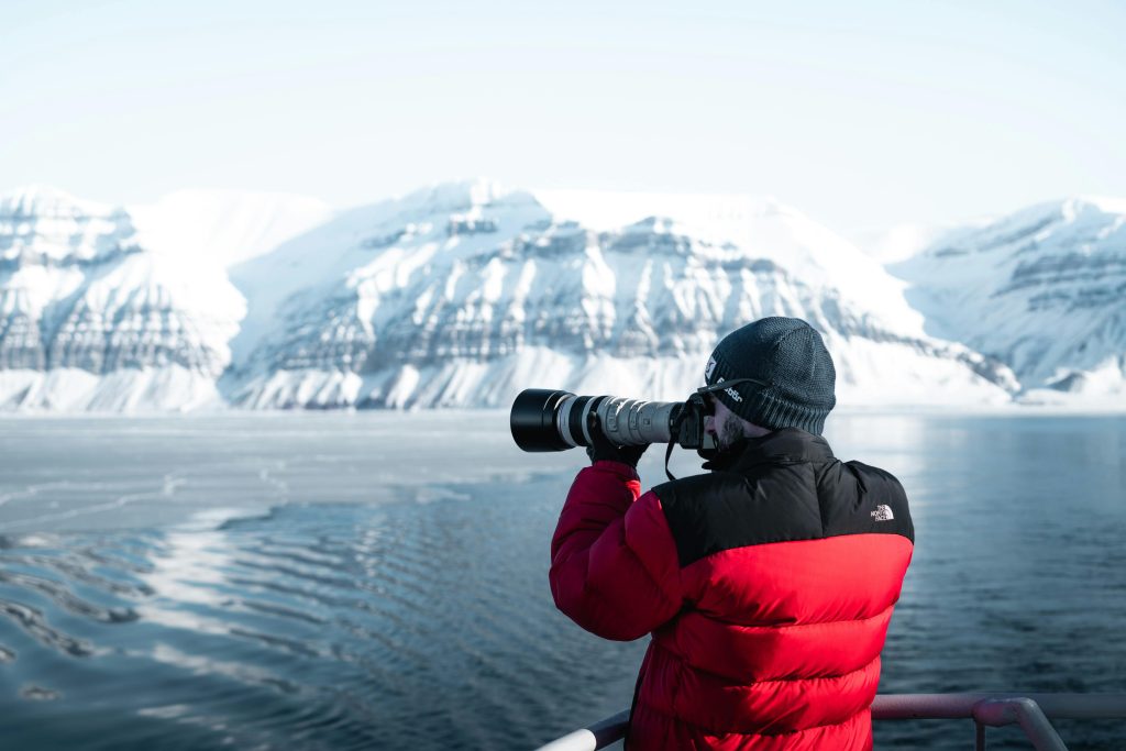 Mann macht Foto im Eismeer